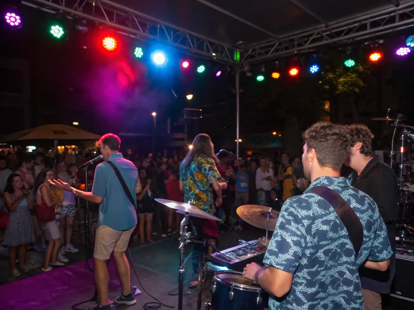 A vibrant photograph capturing the energy of a live music performance at Sabor Denver, with a band on stage and a crowd of people dancing and enjoying the music.
